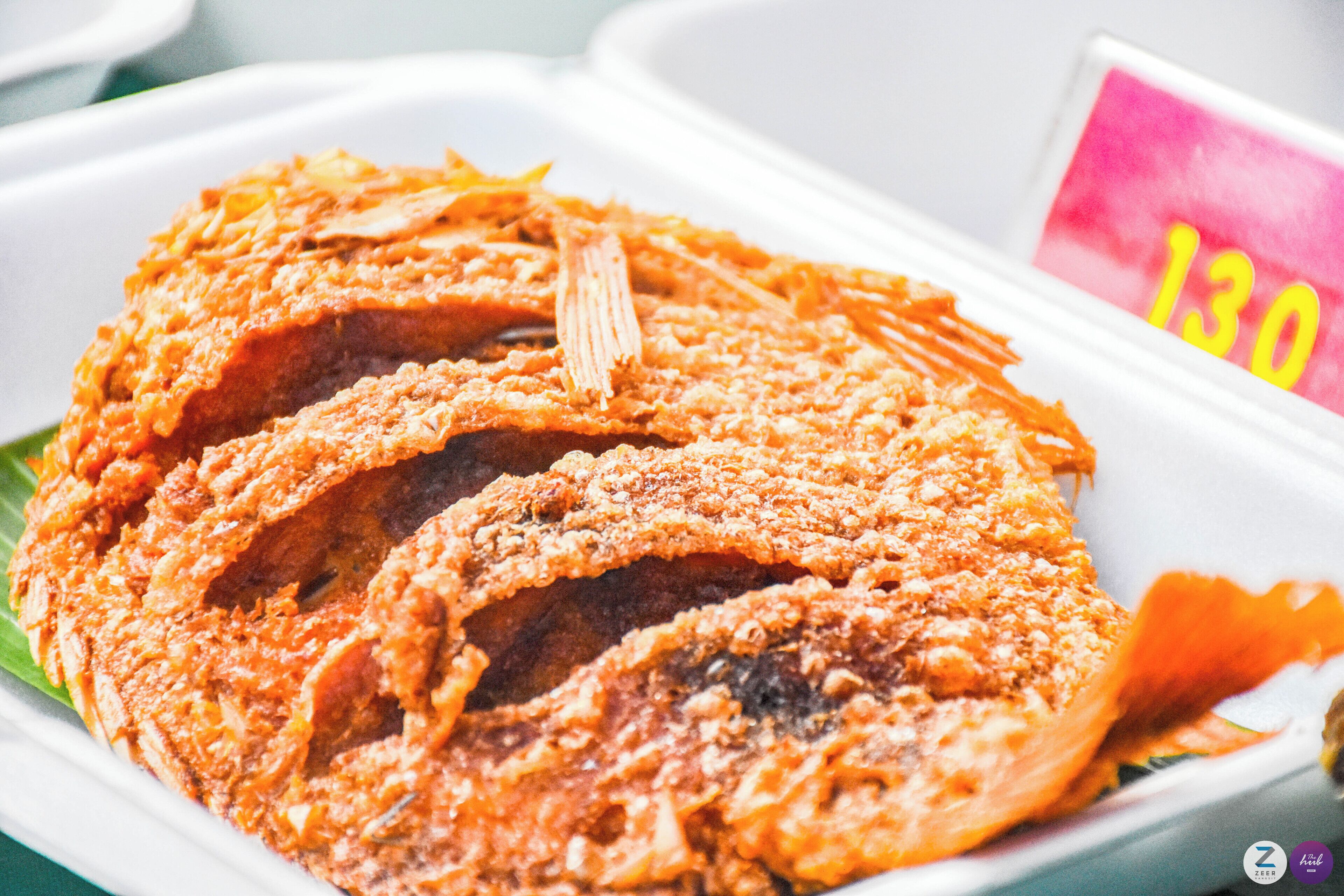 A tray of fried fish with a price tag of 130 visible.