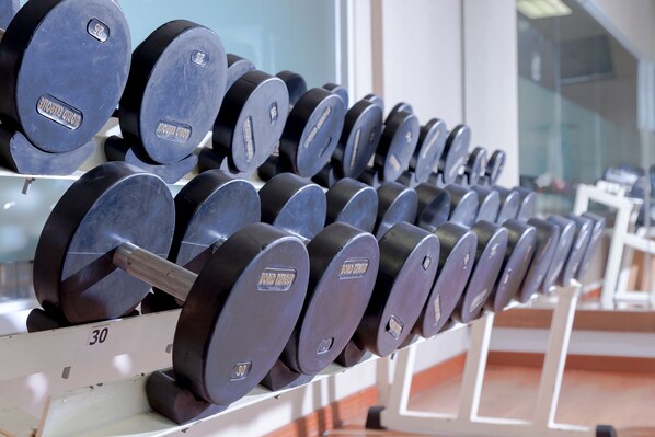 Una hilera de discos de pesas en un estante de gimnasio.