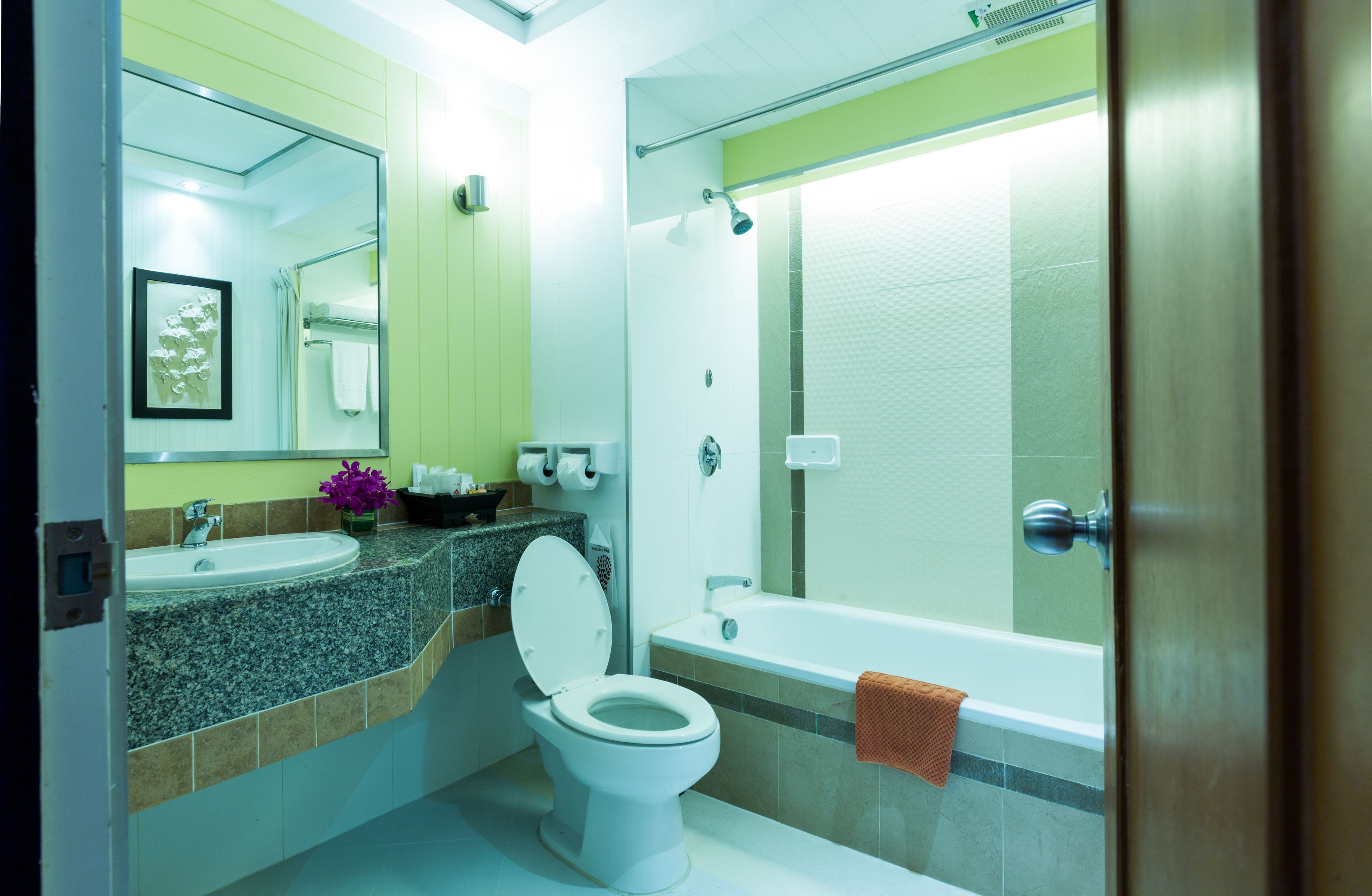 A modern bathroom with a sink, toilet, and bathtub.