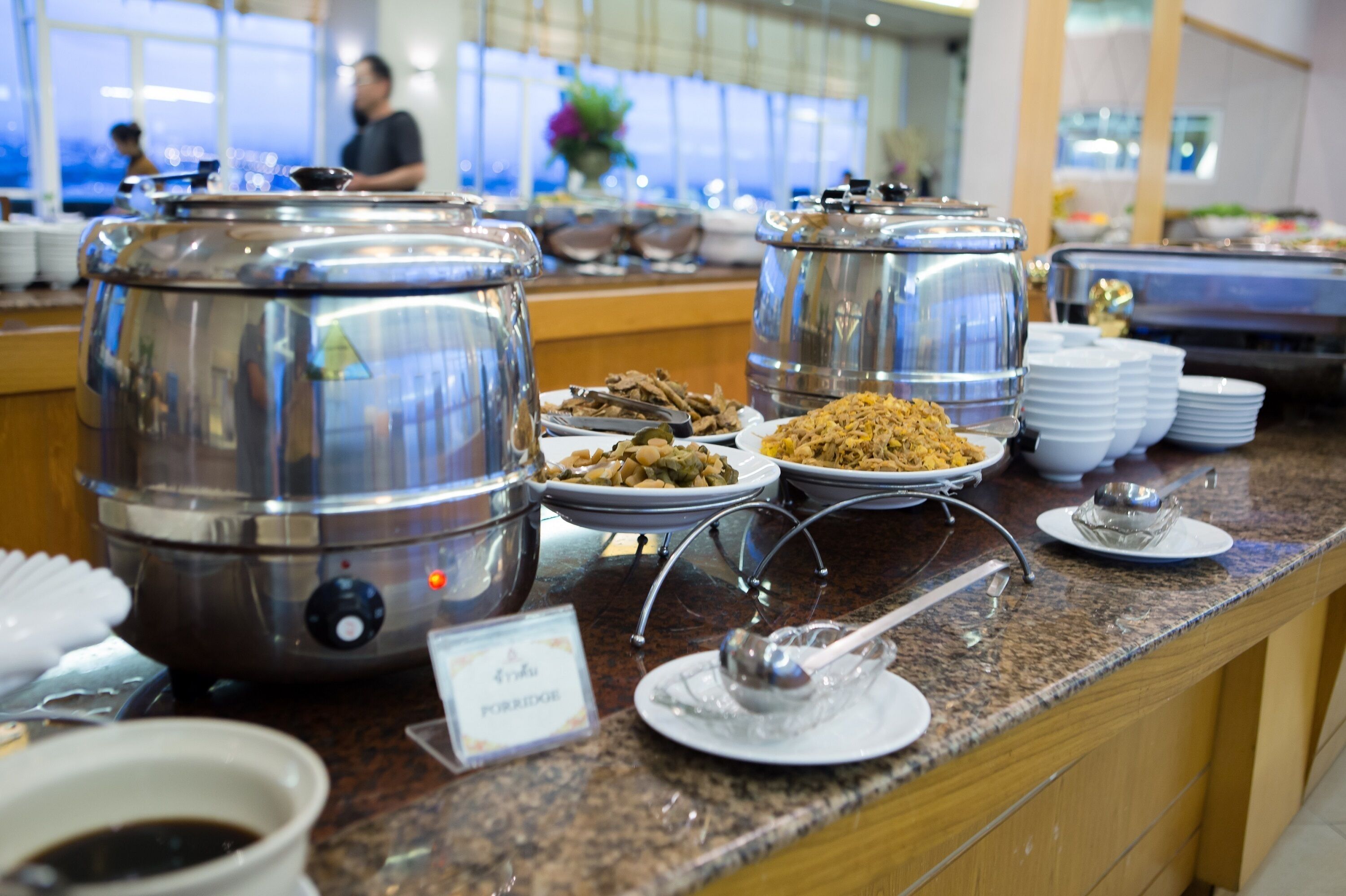 A buffet setup with multiple food dispensers and plates.