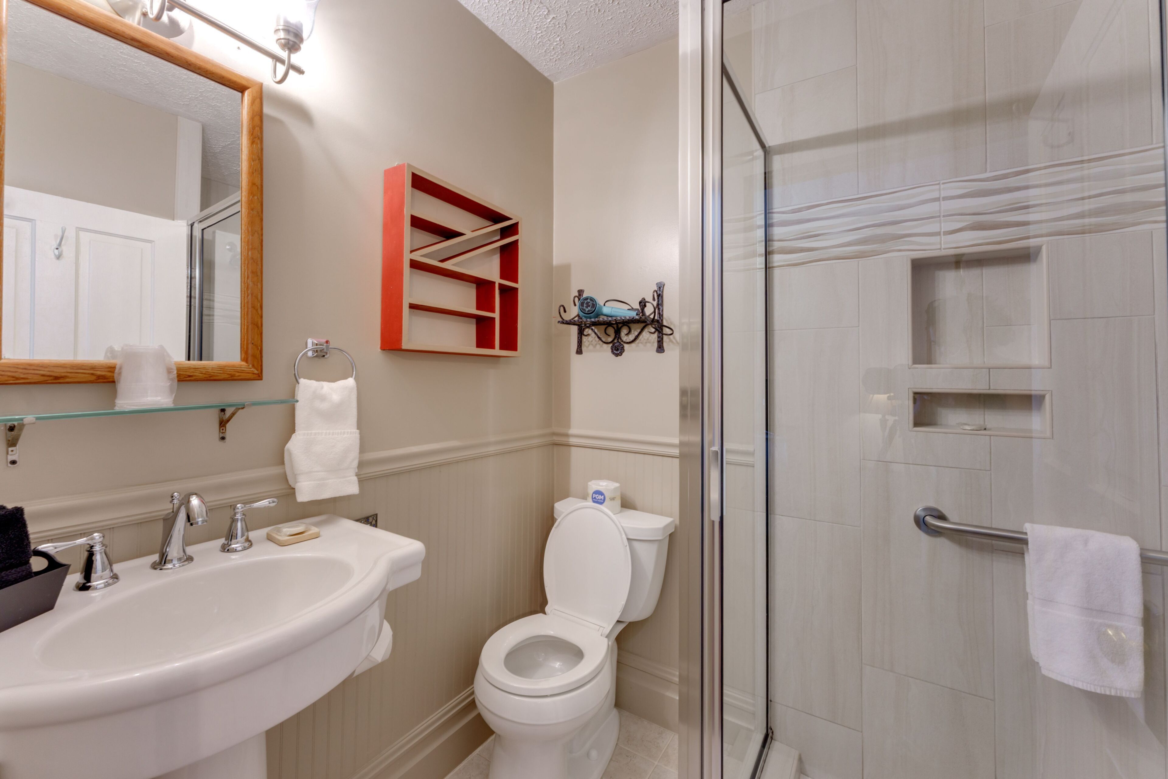 Een badkamer met een wastafel, toilet en douchecabine.