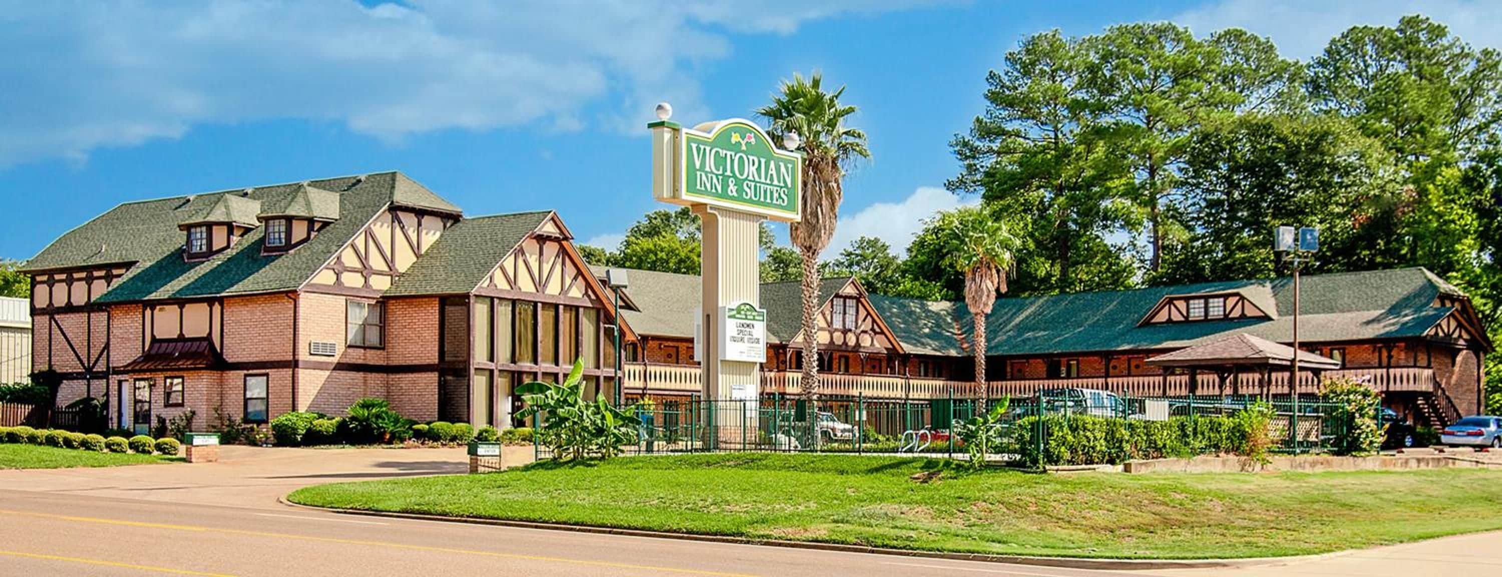 A Victorian Inn & Suites with a traditional architectural style, including timber framing and a prominent sign.