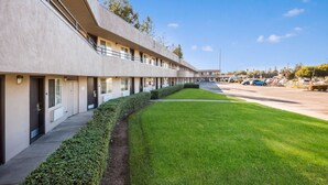 A modern building with a long row of rooms, a well-maintained lawn, and a parking area in the background. - Americas Best Value Inn Santa Rosa, CA (Santa Rosa)