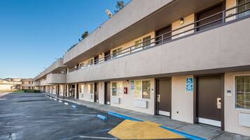 A multi-story hotel with a parking lot and accessible parking spaces.