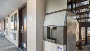 A row of hotel rooms with a kitchenette area featuring a water dispenser and a small sink. - Americas Best Value Inn Santa Rosa, CA (Santa Rosa)