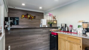 A modern kitchen with wooden cabinetry, a built-in microwave, and a coffee station. - Americas Best Value Inn Santa Rosa, CA (Santa Rosa)