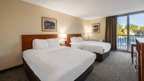 A hotel room with two beds, a large window with a view, and a desk with a chair. - Quality Inn & Suites Canon City (Canon City)