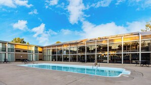A swimming pool with a glass building in the background. - Quality Inn & Suites Canon City (Canon City)