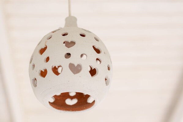 A white spherical object with heart-shaped cutouts, hanging from a string. - ECO Lifestyle & Lodge (Bathsheba)