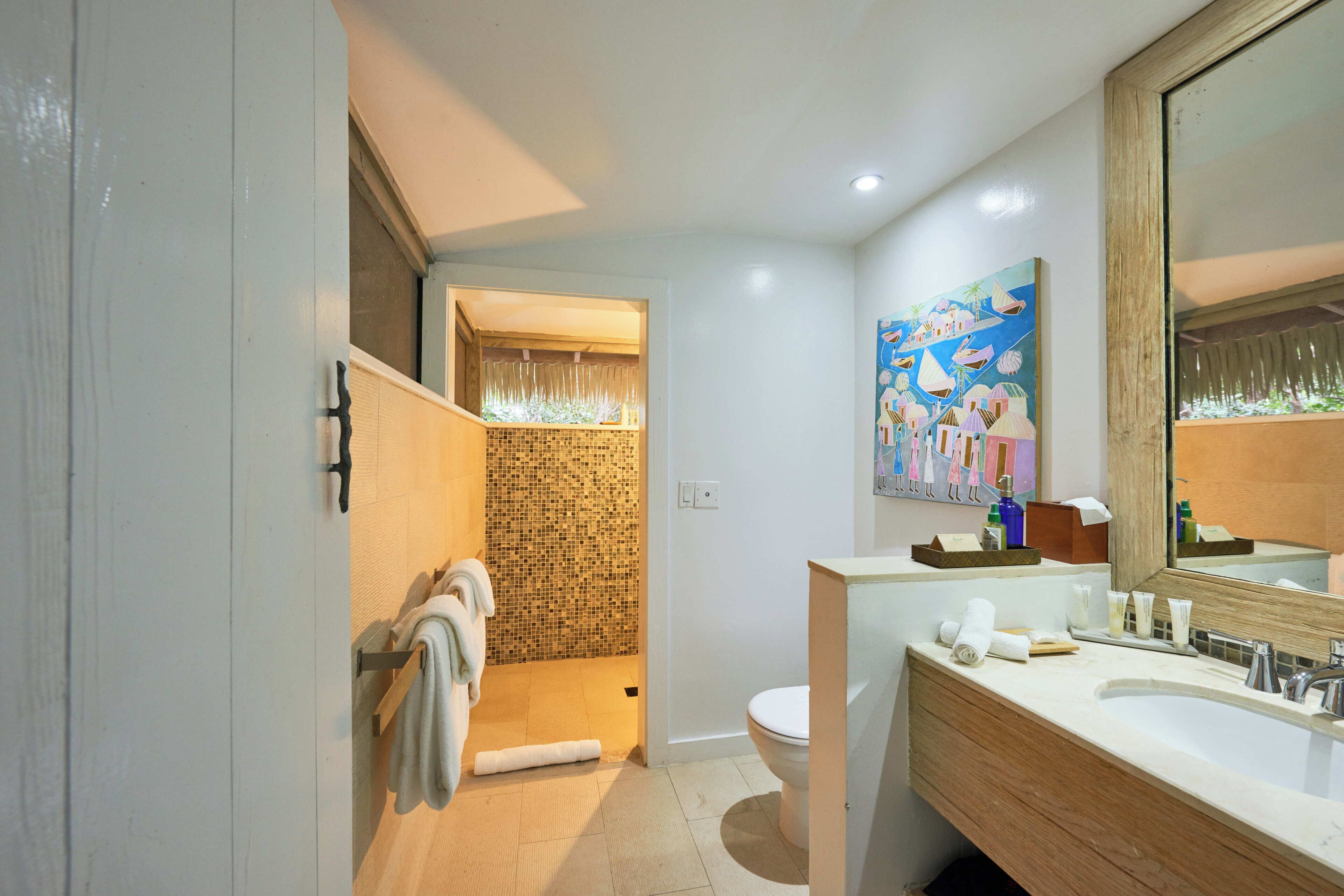 A modern bathroom with a shower, toilet, and sink.