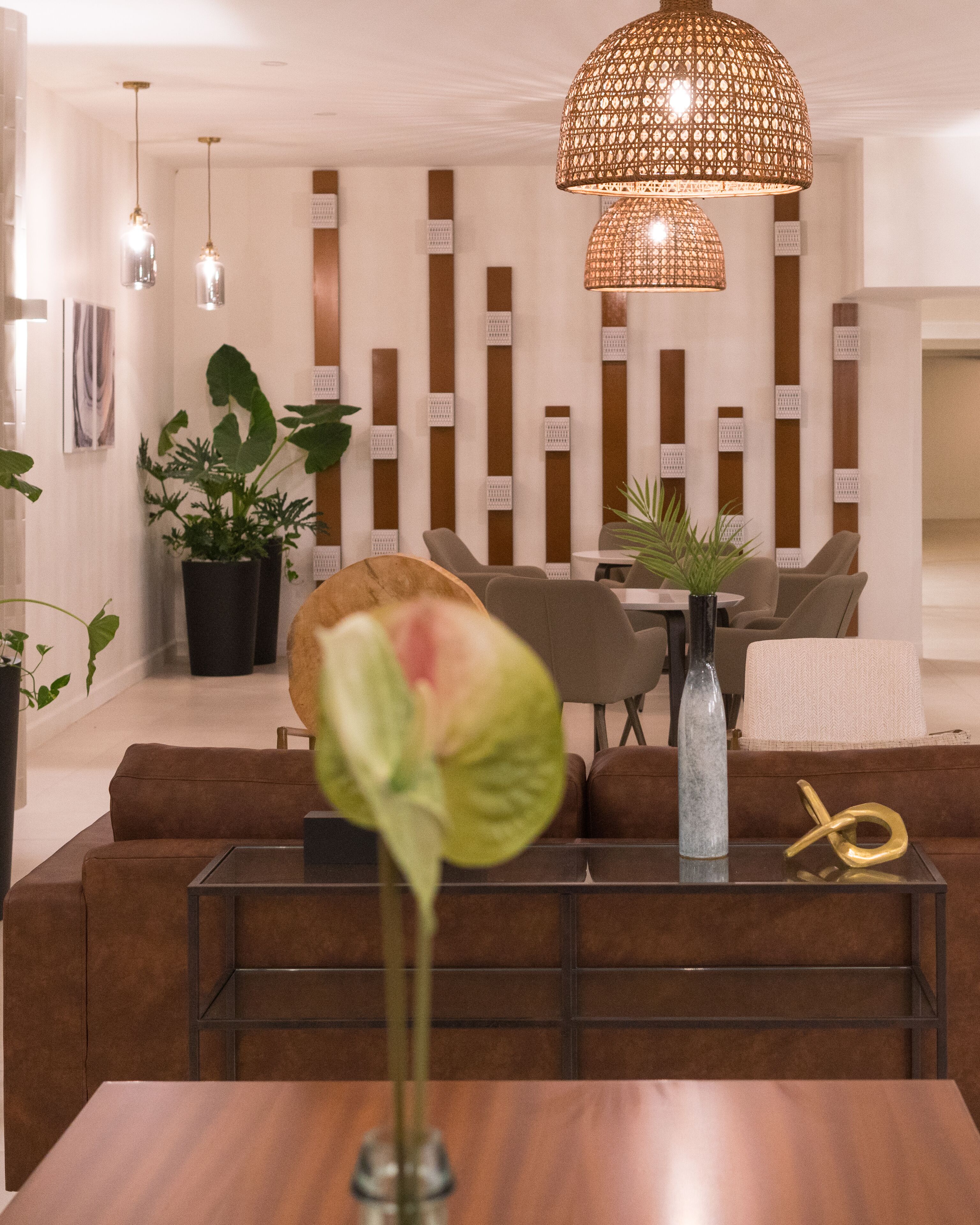 A modern living room with a sofa set, a coffee table, and a decorative vase with a plant.