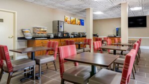 A restaurant with multiple tables and booths, equipped with kitchen appliances and a flat-screen TV on the wall. - Comfort Inn & Suites Statesboro - University Area (Statesboro)