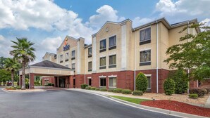 A hotel with a covered entrance, multiple windows, and a brick facade. - Comfort Inn & Suites Statesboro - University Area (Statesboro)