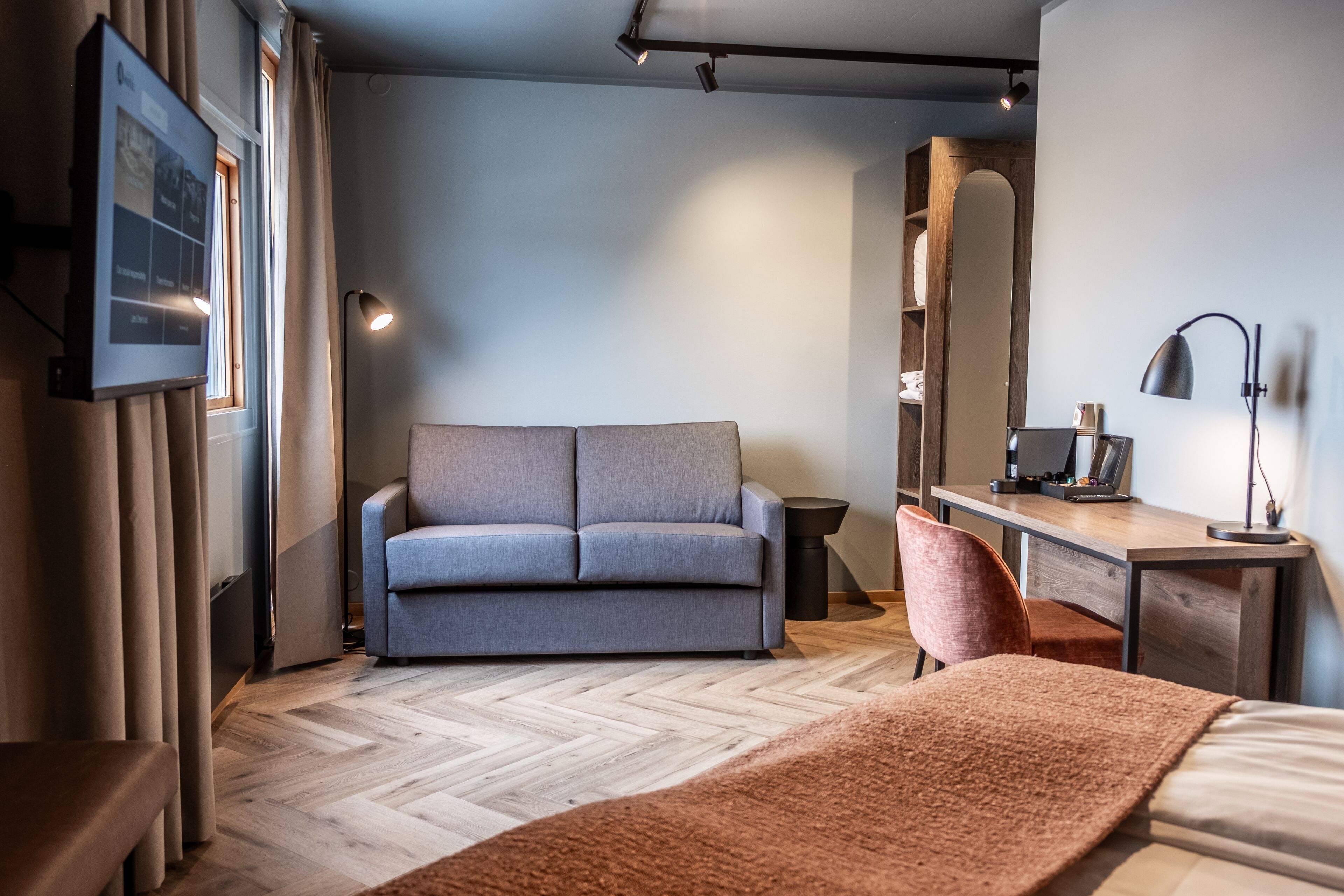 Un dormitorio moderno con sofá, escritorio y cama.