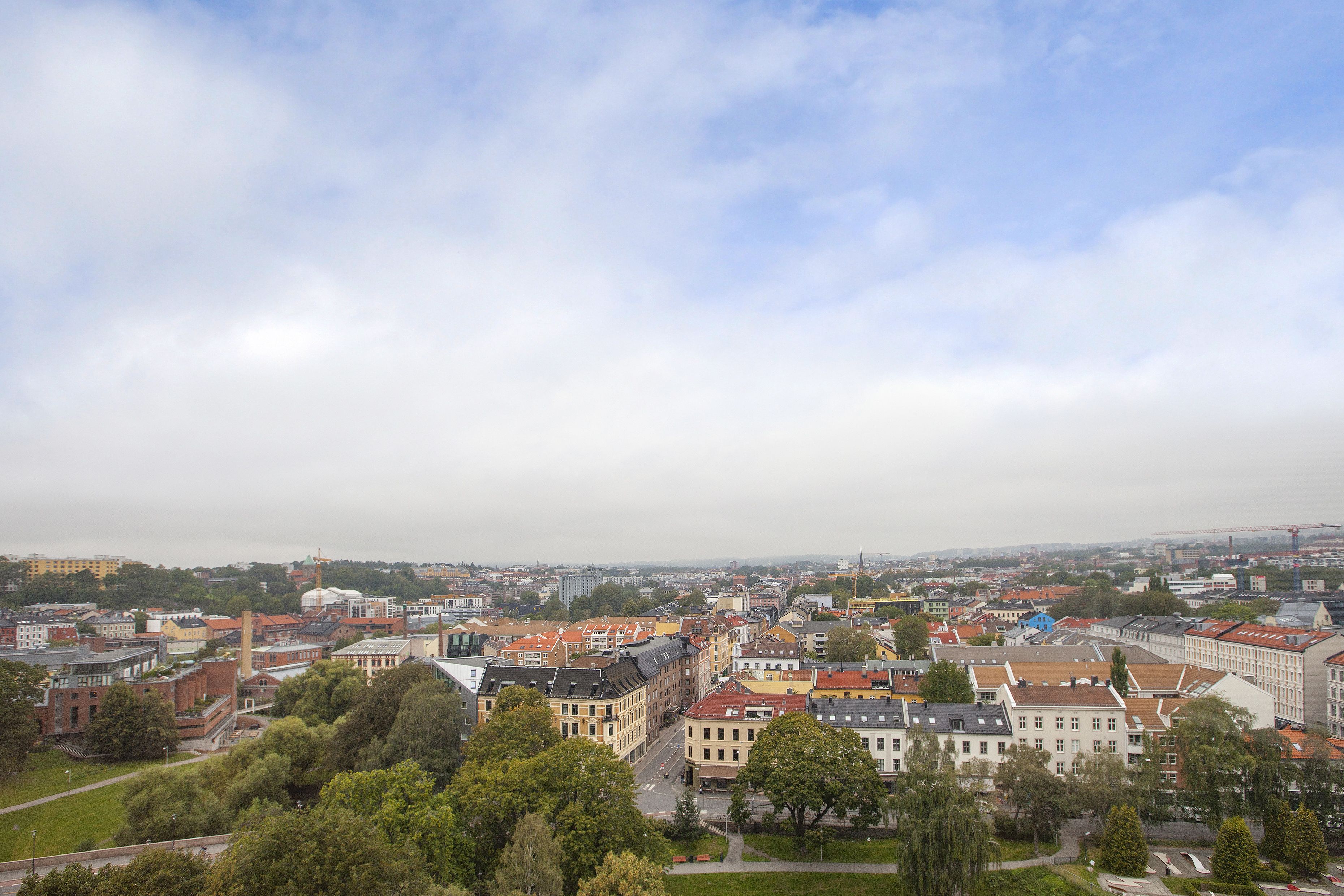 A cityscape with a mix of historic and modern buildings, a prominent church spire, and a clear view of the surrounding urban area.