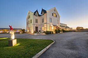A large, multi-story building with a modern architectural style, featuring a prominent entrance and a well-maintained lawn.