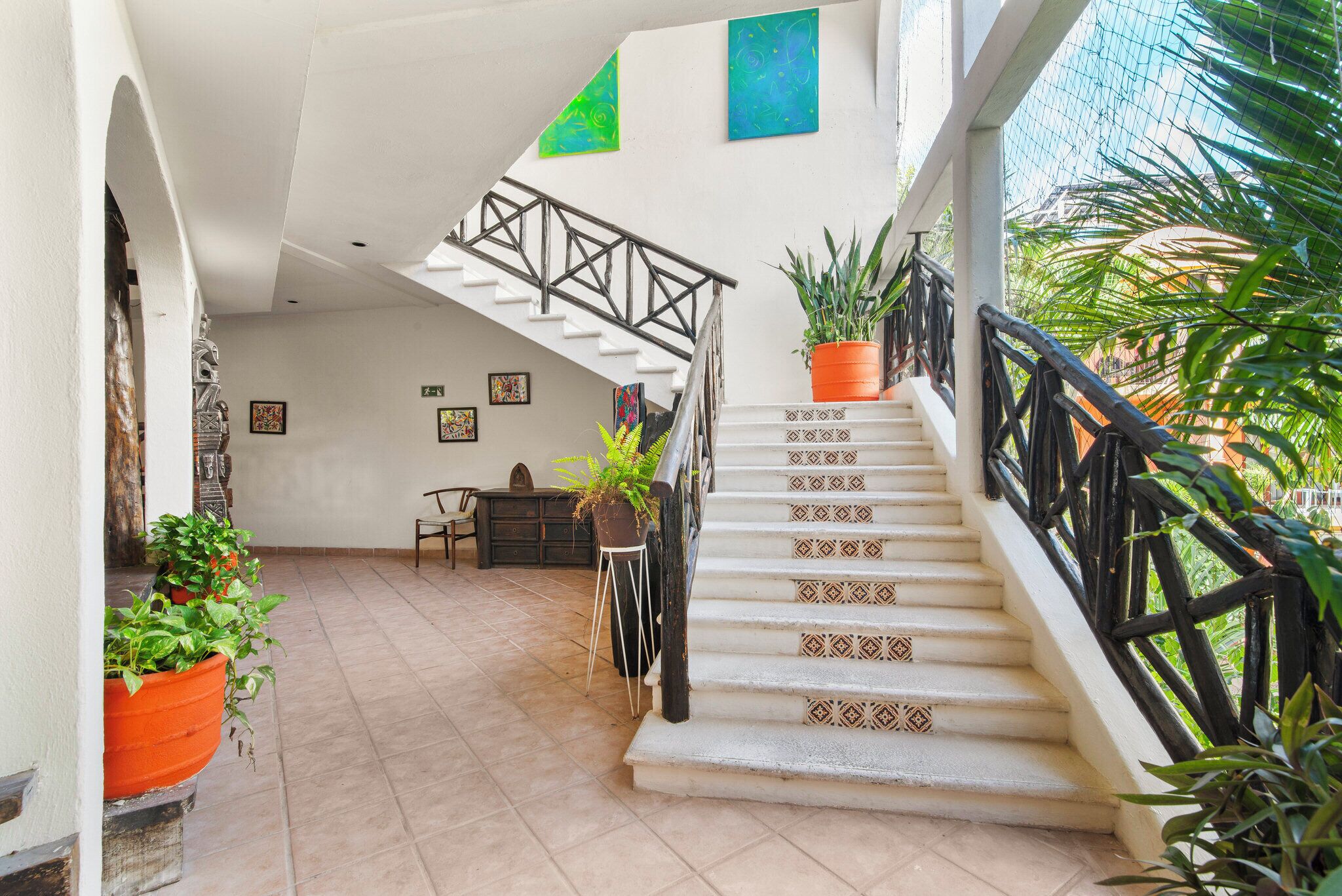 Un escalier avec des marches décorées et une rampe noire, menant à un niveau supérieur.