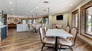 A restaurant with a central island, booths, and a long table. - Econo Lodge Lakeview (Marquette)