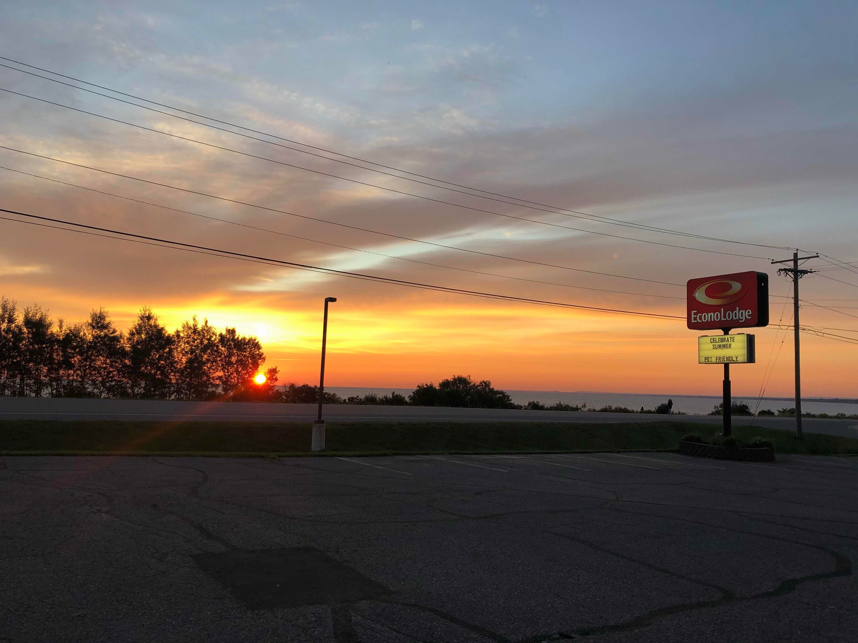 A sunset view with a sign for Econo Lodge, a pet-friendly establishment.