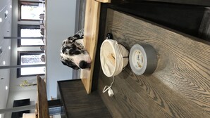 A dog peering over a counter in a cafe with a cup and a roll of tape on the counter. - Econo Lodge Lakeview (Marquette)