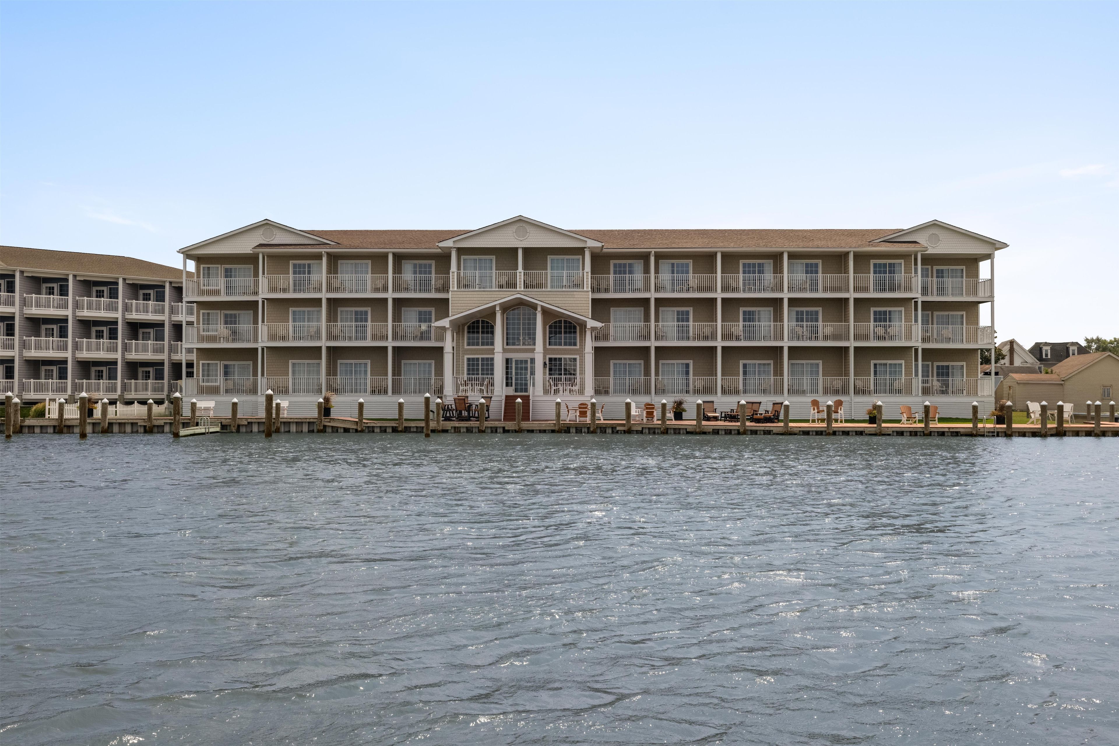 A multi-story hotel with balconies, a dock, and outdoor seating.