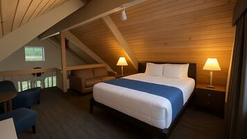 A bedroom with a bed, two bedside lamps, a nightstand, a chair, a sofa, and a window.