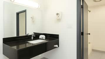 A modern bathroom with a black sink, a mirror, and a toilet.