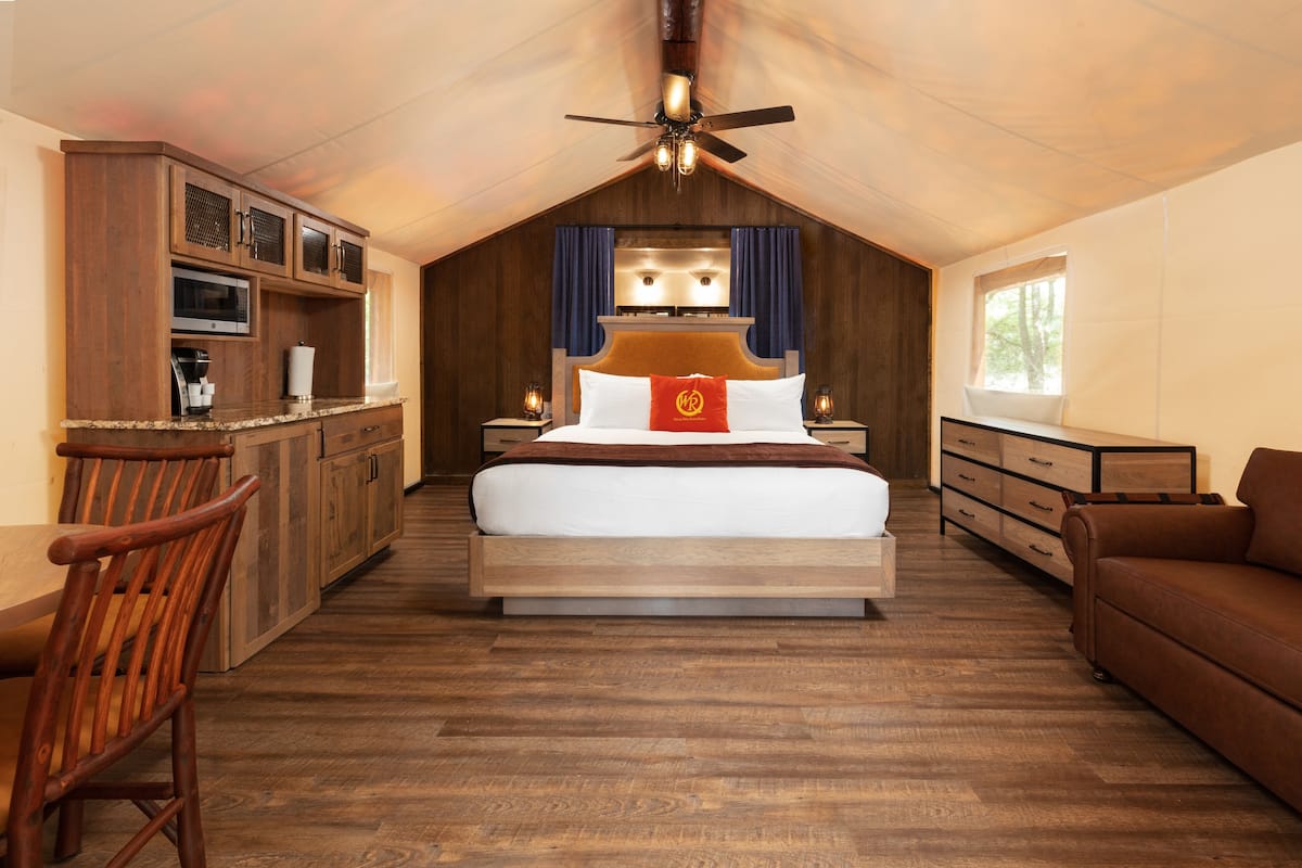 Une chambre à coucher avec un grand lit, des armoires en bois, un bureau et une chaise.