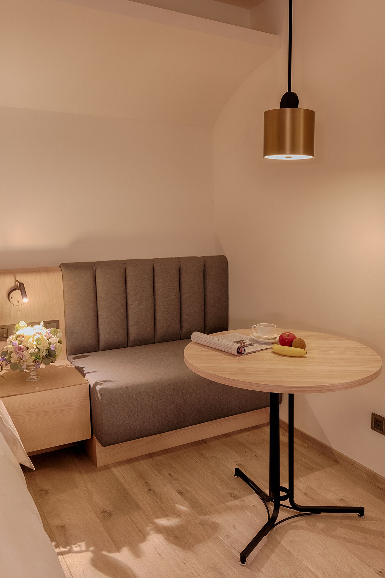 A modern room with a sofa, a round table, and a pendant light.