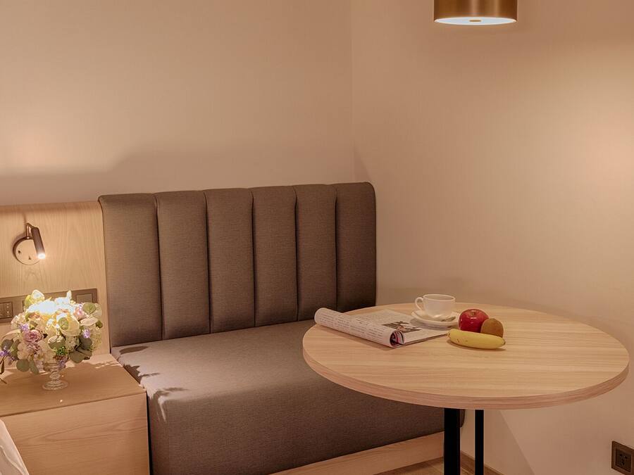 A modern room with a sofa, a round table, and a pendant light.