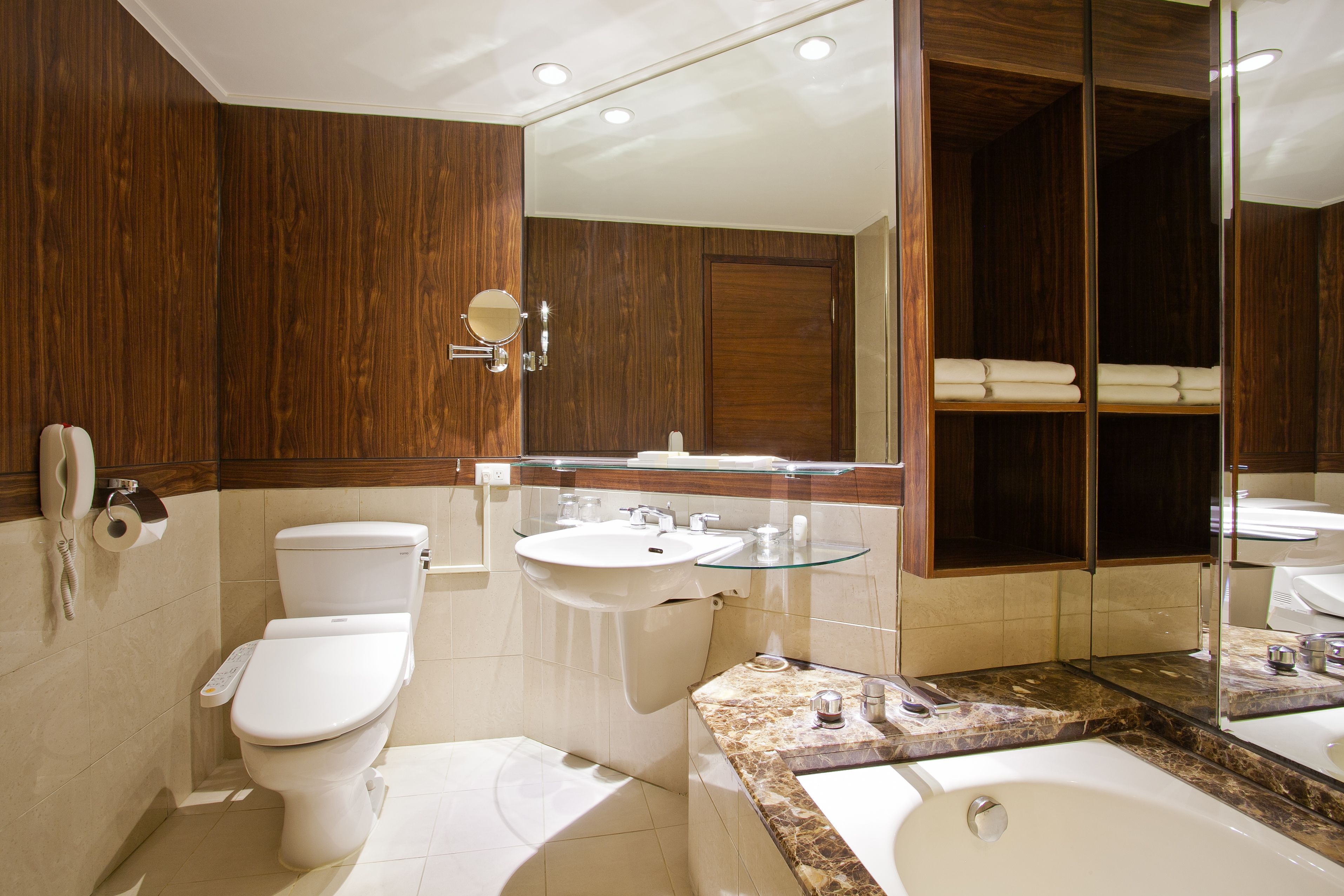 A modern bathroom with a toilet, sink, and bathtub.