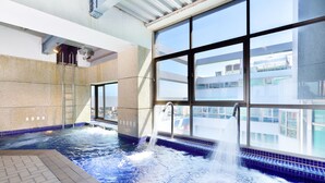 Een jacuzzi met uitzicht op de stad door grote ramen.