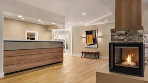 A modern interior with a wooden reception desk, a fireplace with a mosaic surround, and a bench. - Residence Inn by Marriott Sacramento Folsom (Folsom)