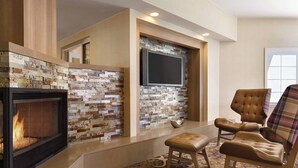 A modern living room with a fireplace, a stone accent wall, a flat-screen TV, and comfortable seating. - Residence Inn by Marriott Sacramento Folsom (Folsom)