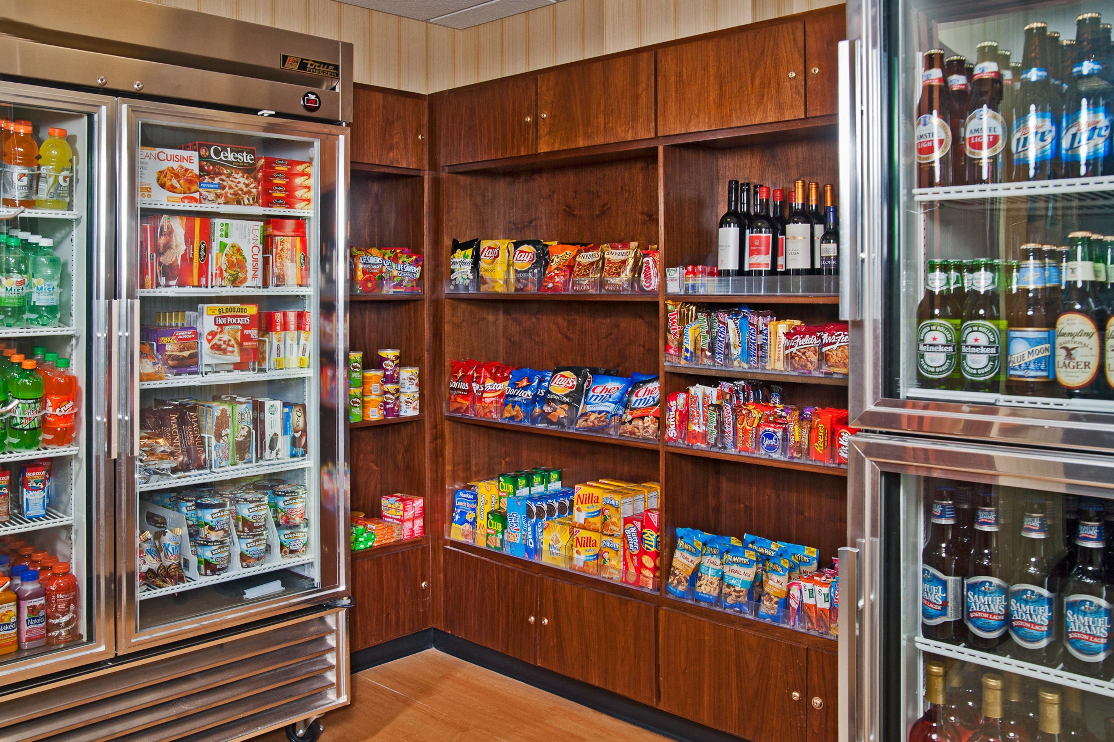 A grocery store with refrigerated sections and shelves stocked with snacks, beverages, and household items.