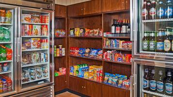 A grocery store with refrigerated sections and shelves stocked with snacks, beverages, and household items.