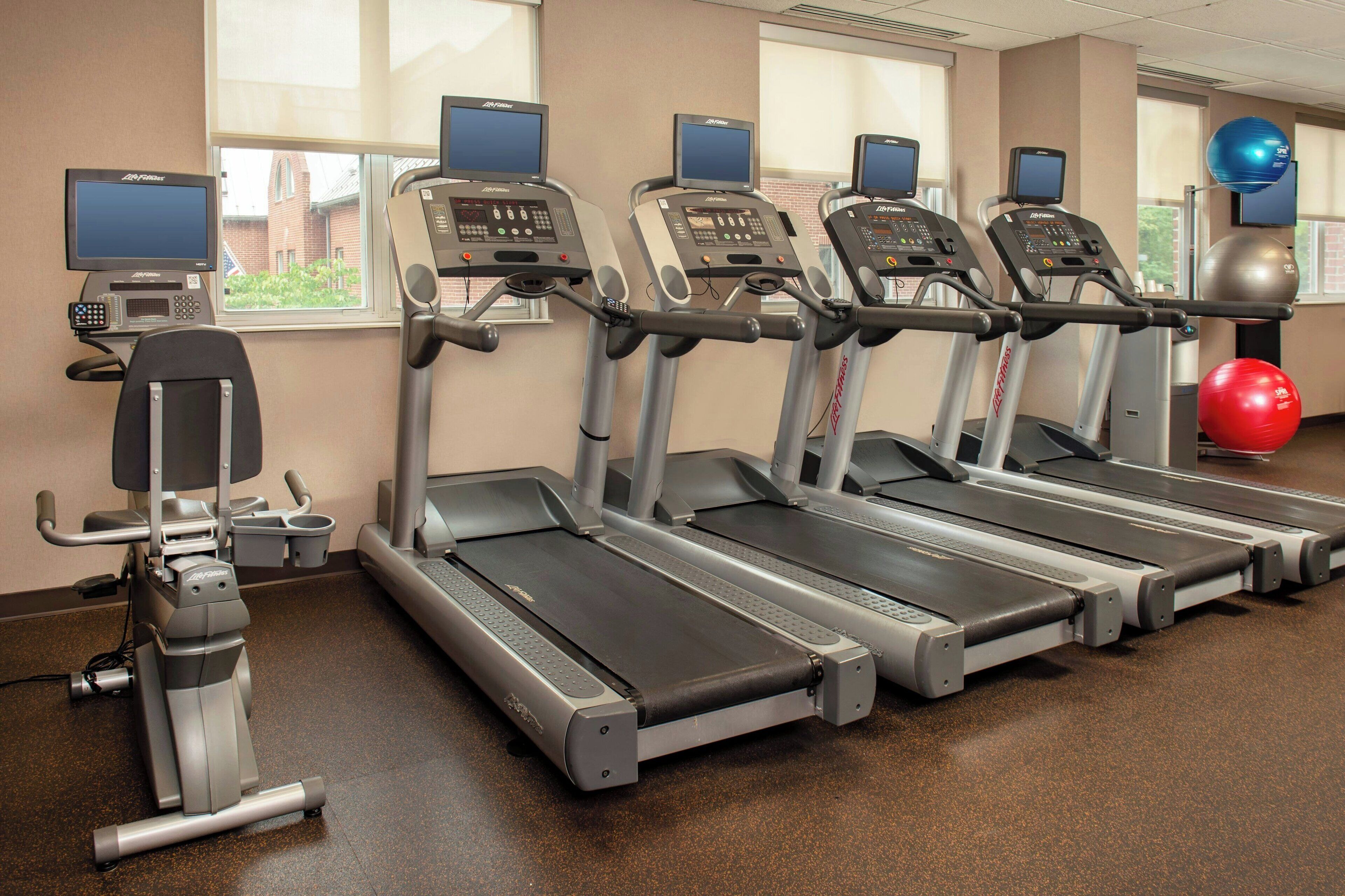 A gym with treadmills, exercise balls, and a stationary bike.