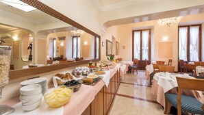 Un comedor con barra libre, que incluye diversos alimentos y una larga mesa con sillas.
