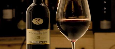 Una botella de vino con etiqueta y una copa sobre una mesa.