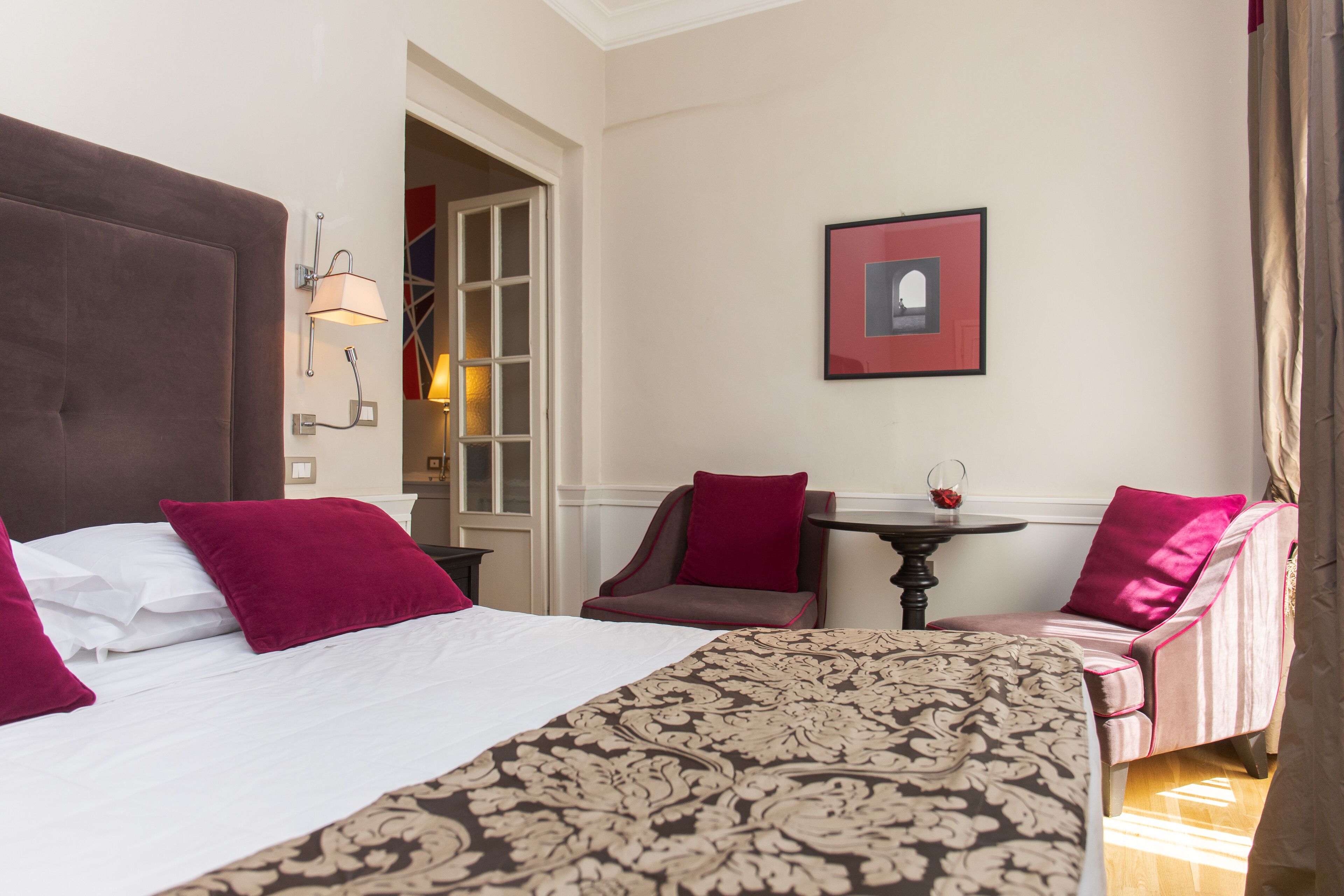 Ein Hotelzimmer mit einem großen Bett, einem kleinen Tisch und zwei Stühlen.
