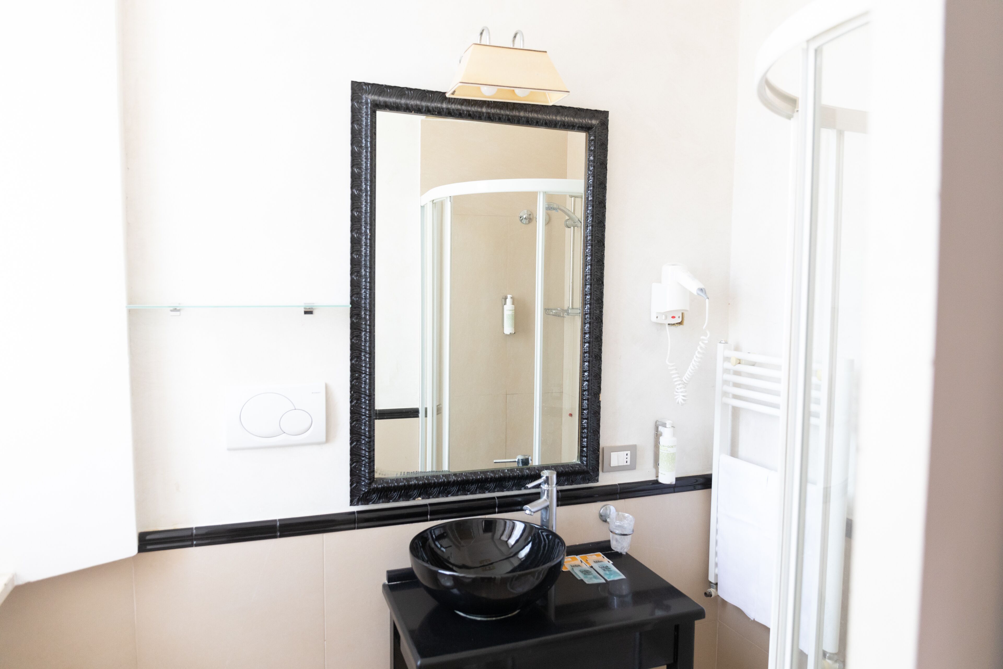 A bathroom with a black sink, a mirror, and a towel rack.