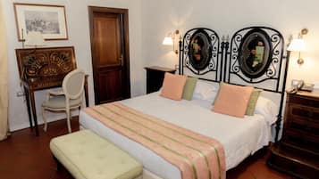 A neatly arranged bedroom with a bed, bedside tables, a chair, and a desk.