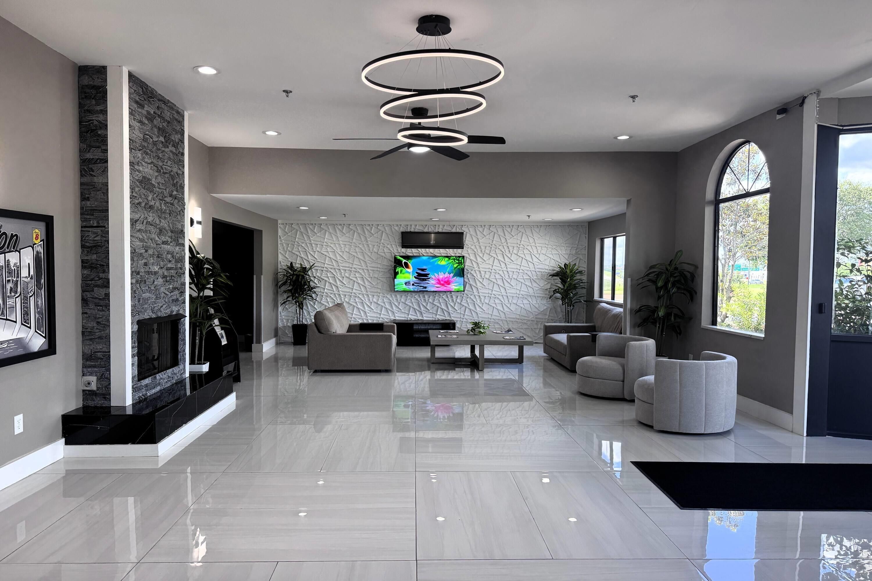 Un espacio habitable amplio con televisor de pantalla plana, mobiliario moderno y un muro decorativo.