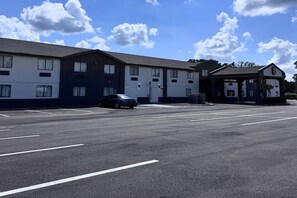 A multi-story building with a parking lot in front.