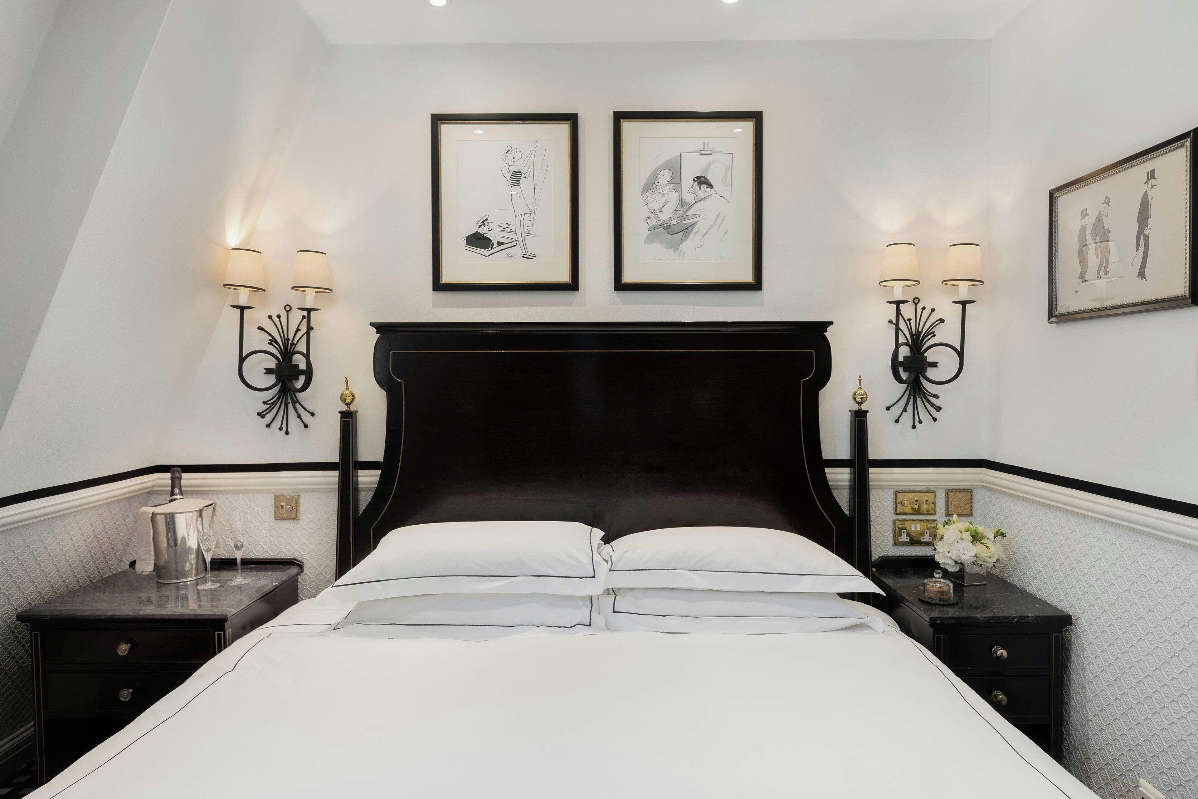 A neatly arranged bedroom with a large bed, two bedside tables, and framed artwork on the walls.