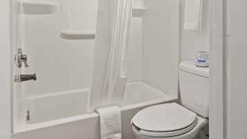 A bathroom with a bathtub, toilet, and shower curtain.