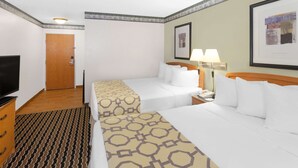 A hotel room with two beds, a TV, a desk, and a lamp. - Baymont by Wyndham Fort Wayne (Fort Wayne)