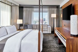 A modern hotel room with a large bed, a sofa, a desk, and a TV. - The Westin Charlotte (Charlotte)