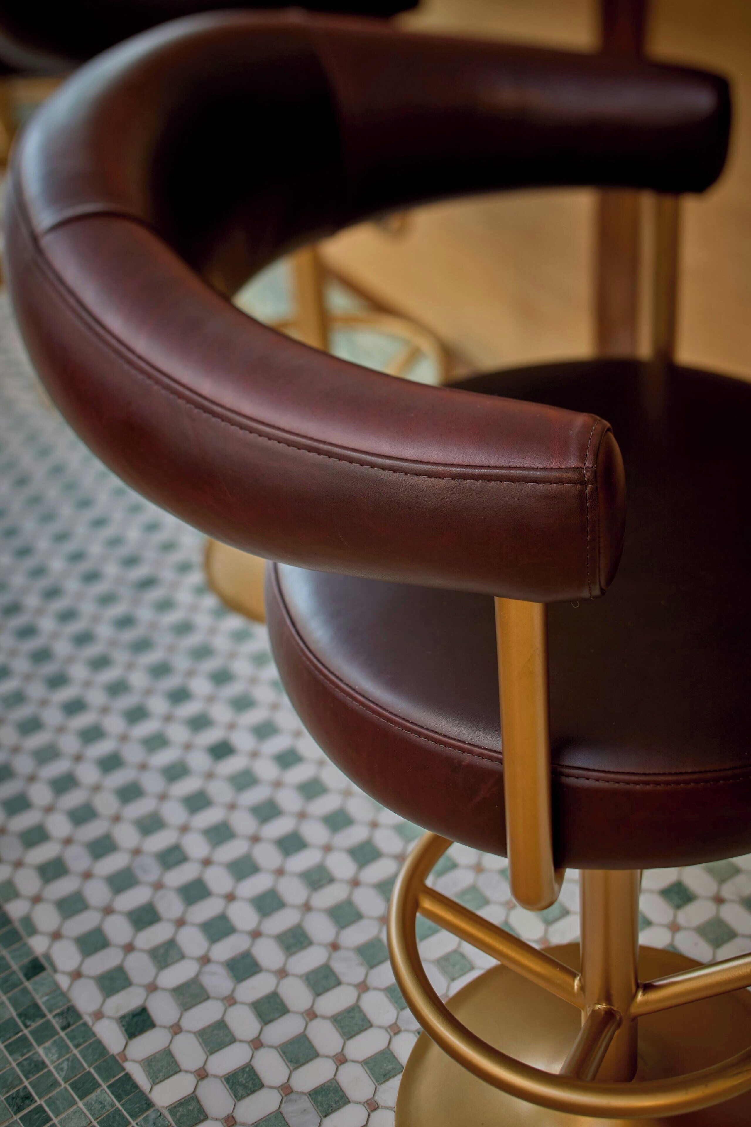 A chair with a curved backrest and a gold metal base.