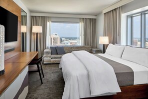 A hotel room with a bed, a desk, a TV, and a view of the cityscape. - The Westin Charlotte (Charlotte)